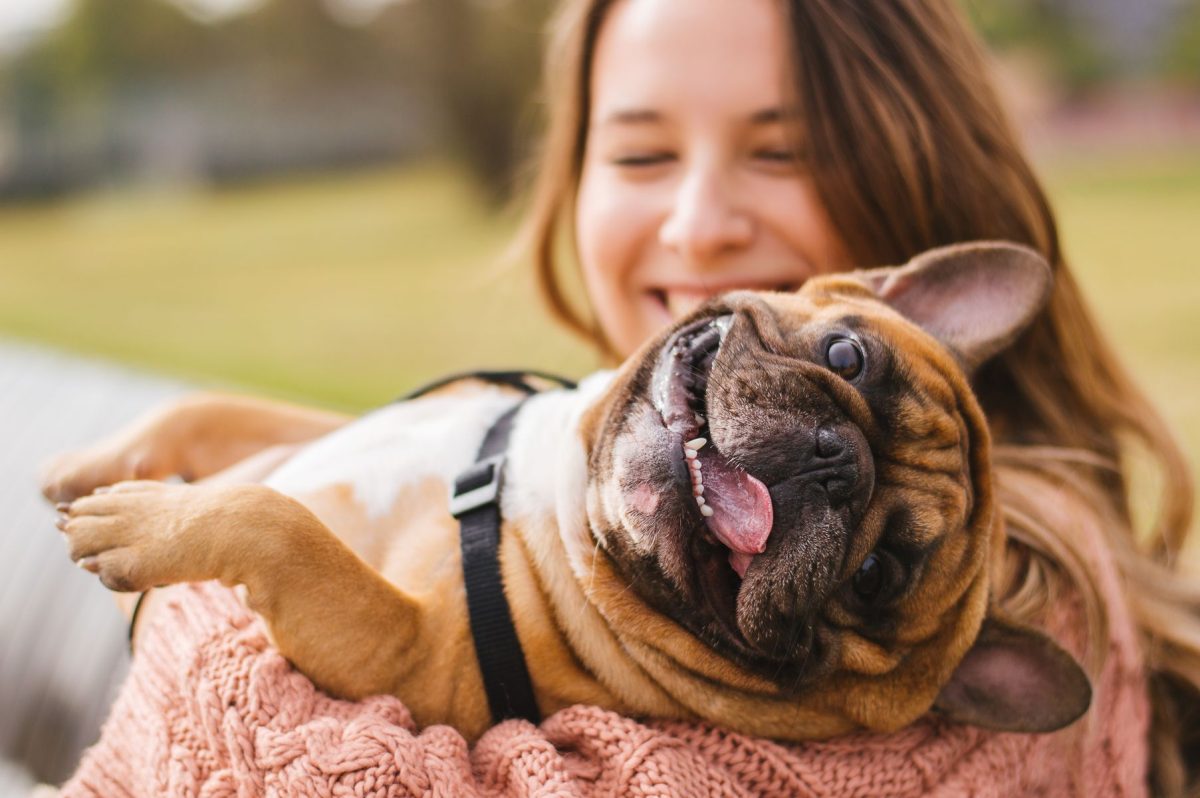 woman holding dog in park
